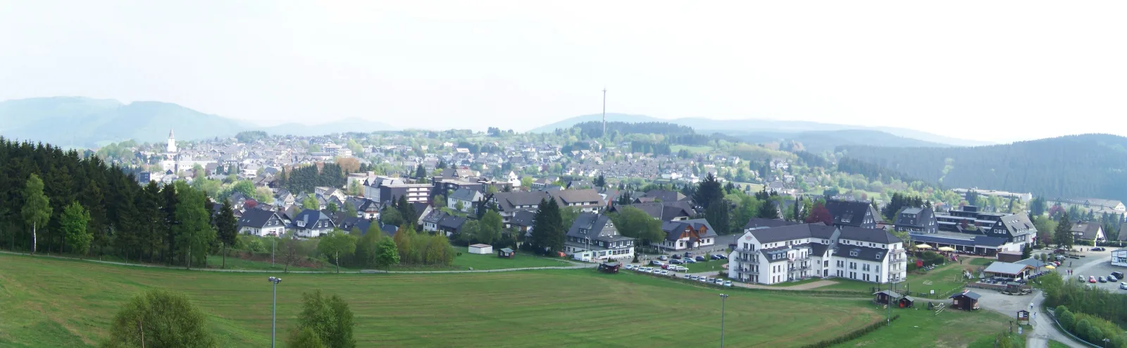 Panoramic view of Winterberg with green hills and a village in the background