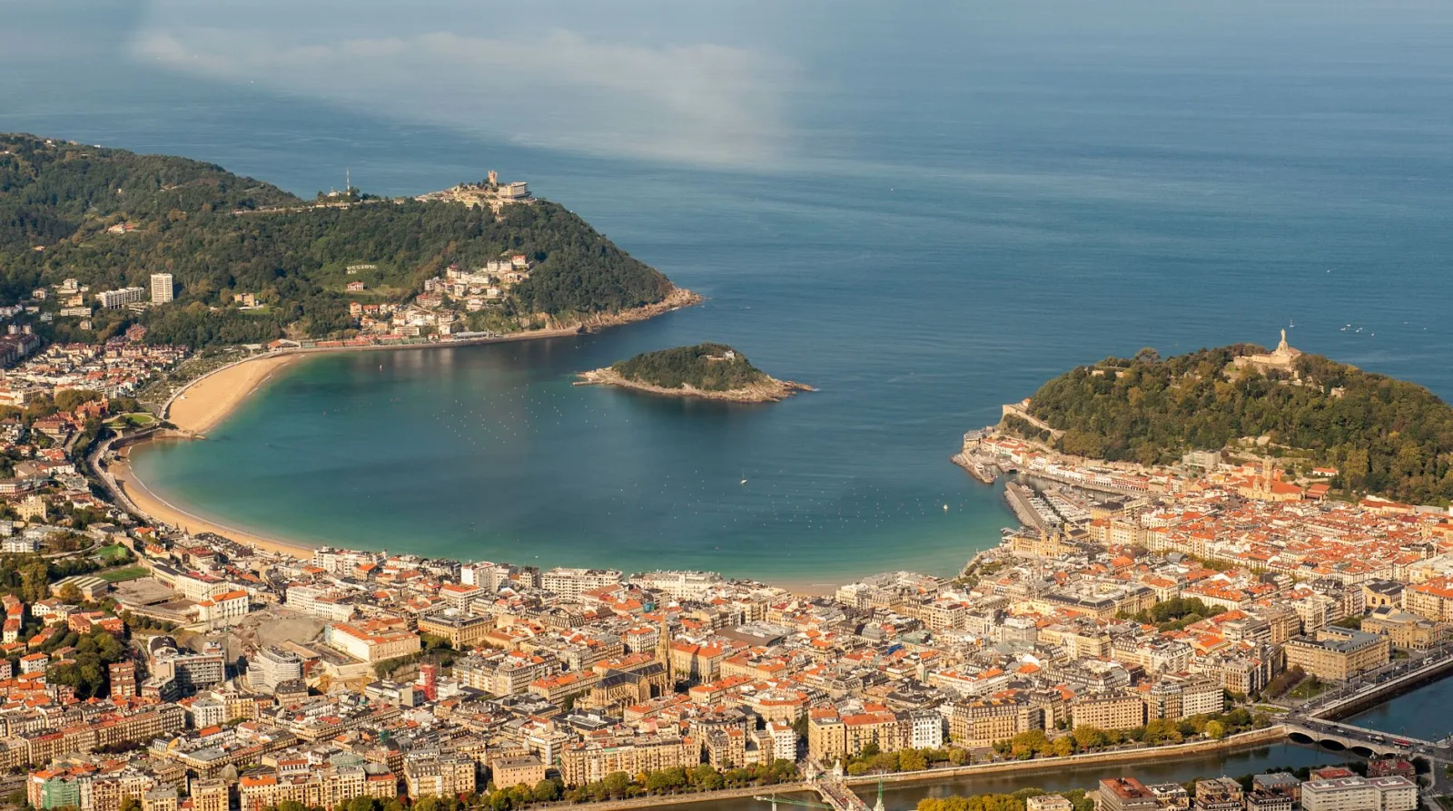 Vista de la bahía de San Sebastián con playa, mar y edificios junto al mar.