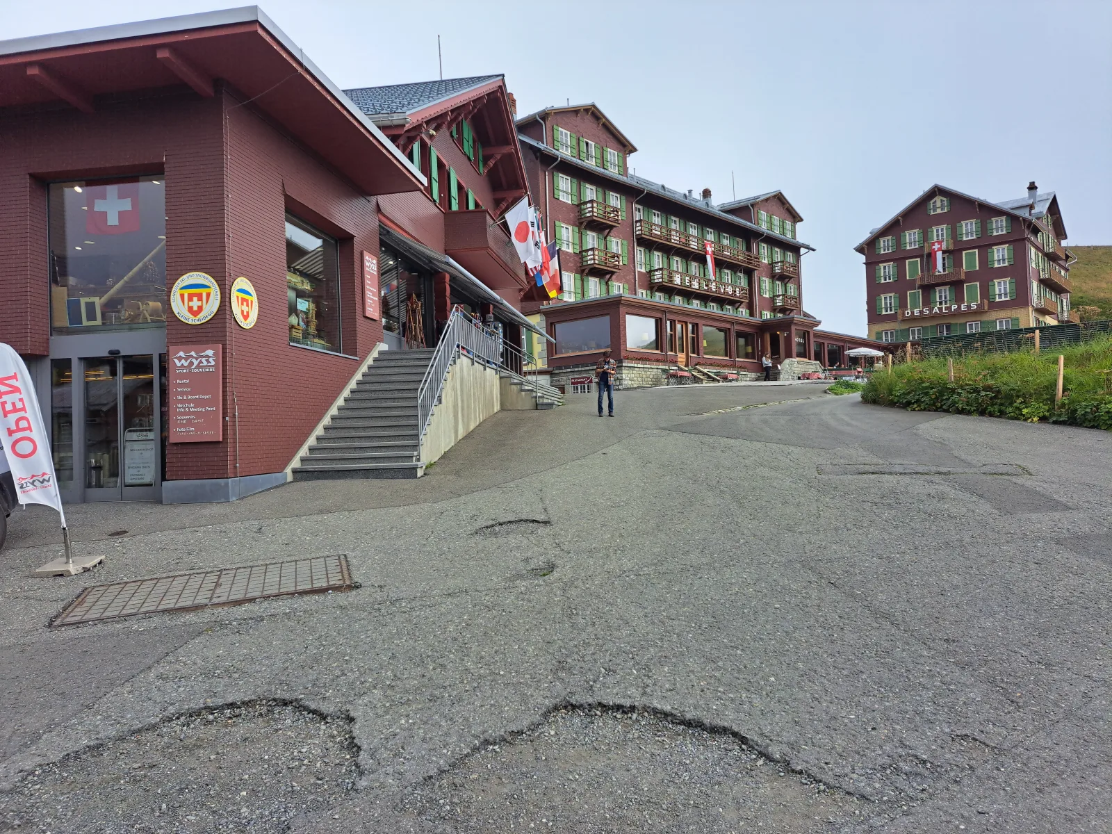 Rua principal de Lauterbrunnen com restaurantes e pousadas típicas ao fundo.
