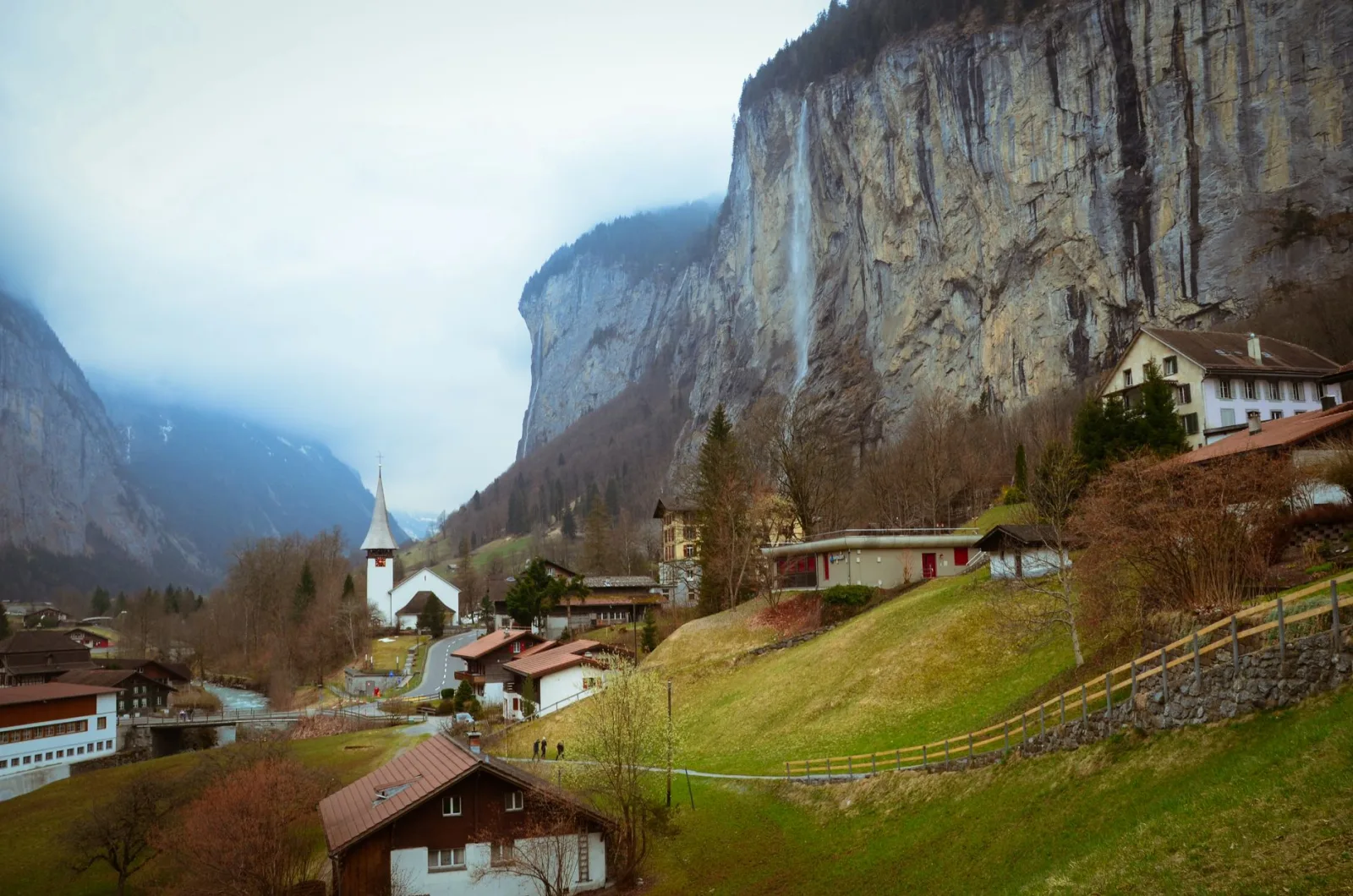 Vale alpino de Lauterbrunnen com montanhas verdes e cachoeiras sob céu claro.