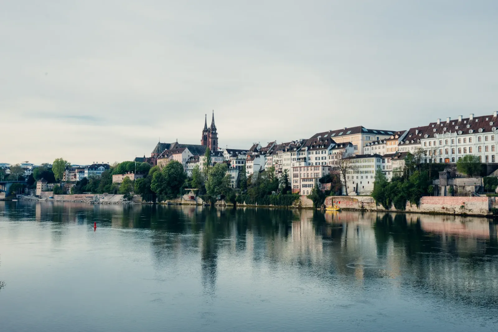 Margem do Reno em Basel com passeio à beira-rio e vista urbana tranquila.