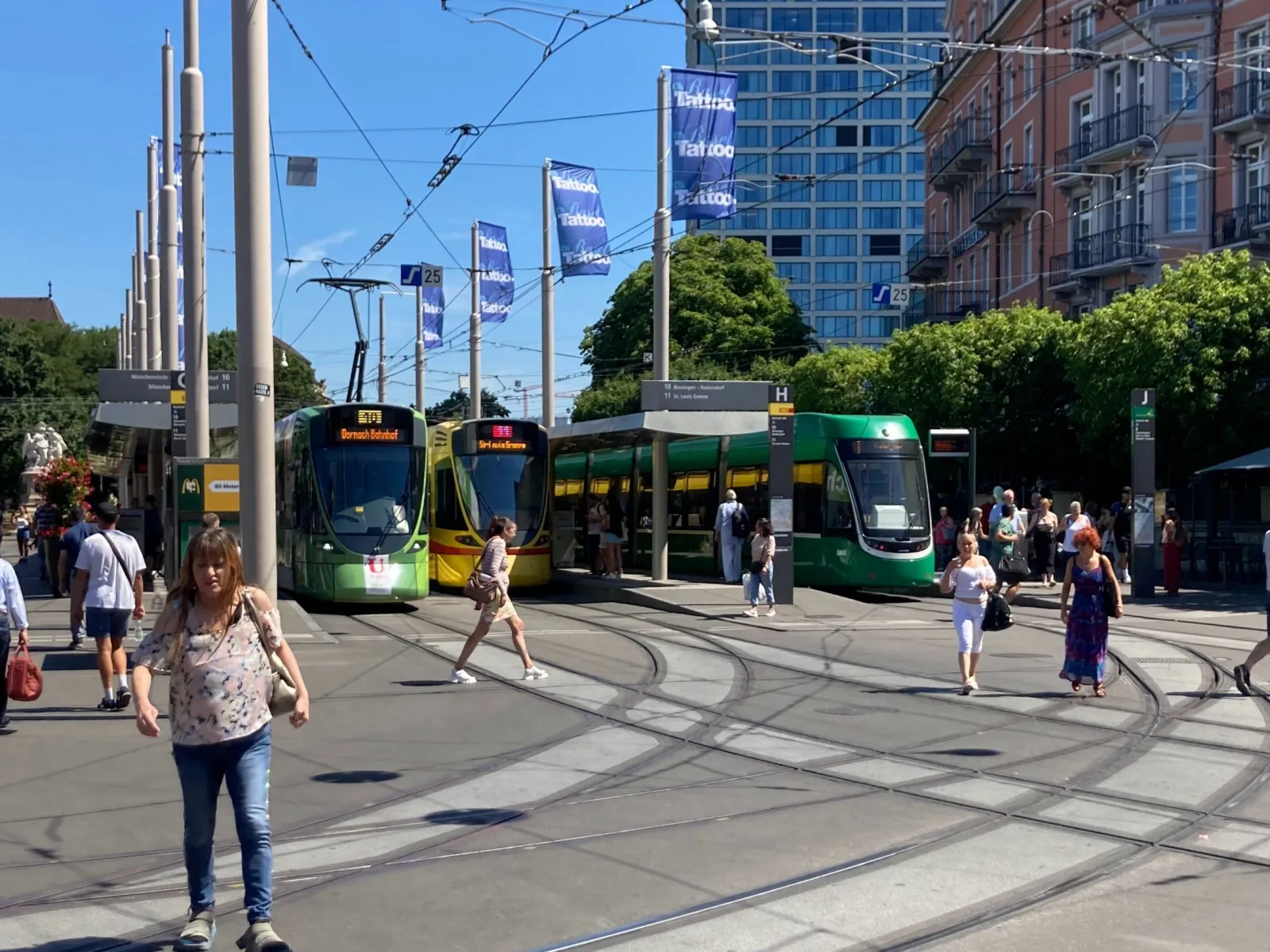 Tram circulando pelo centro de Basel, com prédios históricos ao redor.
