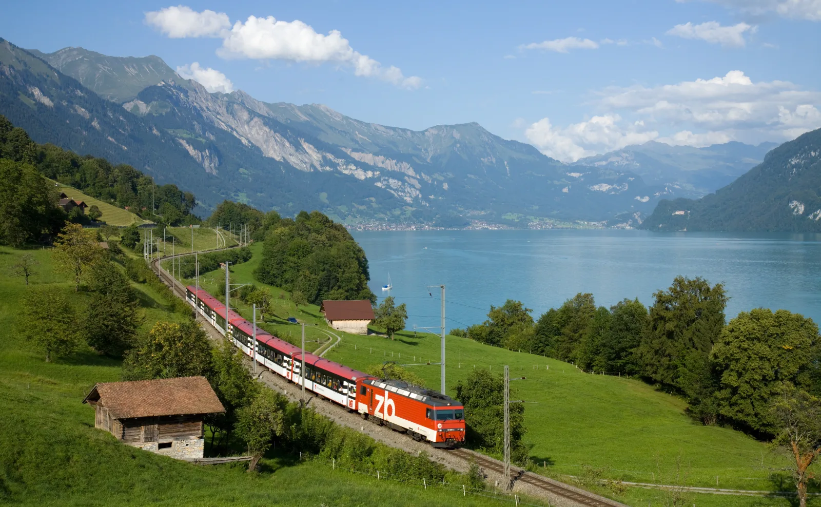 Vista de Brienz à beira do lago, com vilas e montanhas ao fundo.