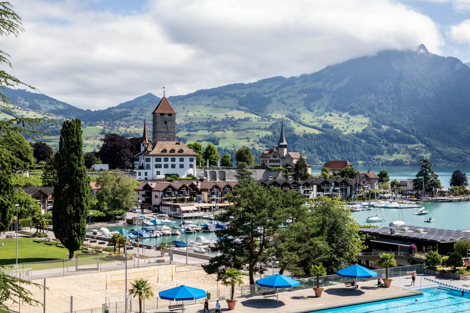 Vila de Brienz à beira do lago, com casas de madeira e montanhas ao fundo.
