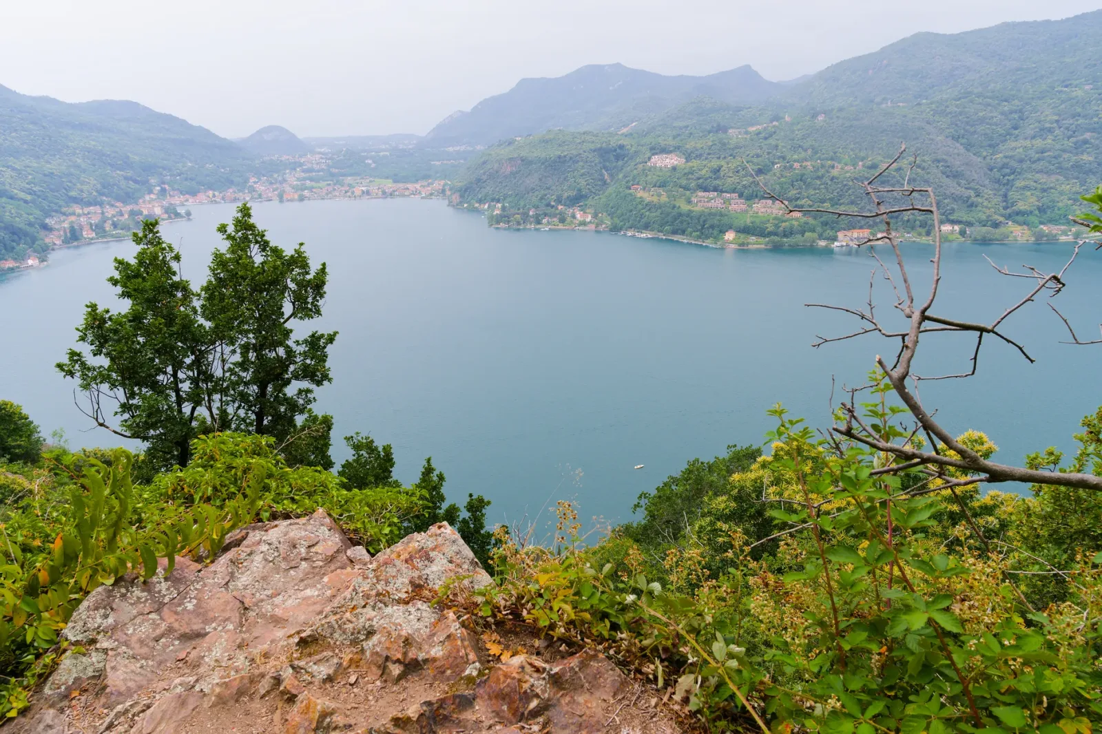 Porto e casas históricas de Morcote à beira do Lago Lugano, com arcadas e cafés.