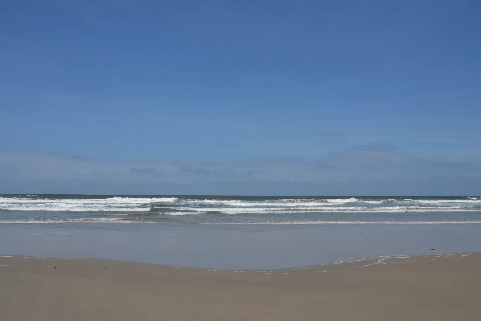 Beach on Ilha do Mel with a crowd of tourists on a peak season day