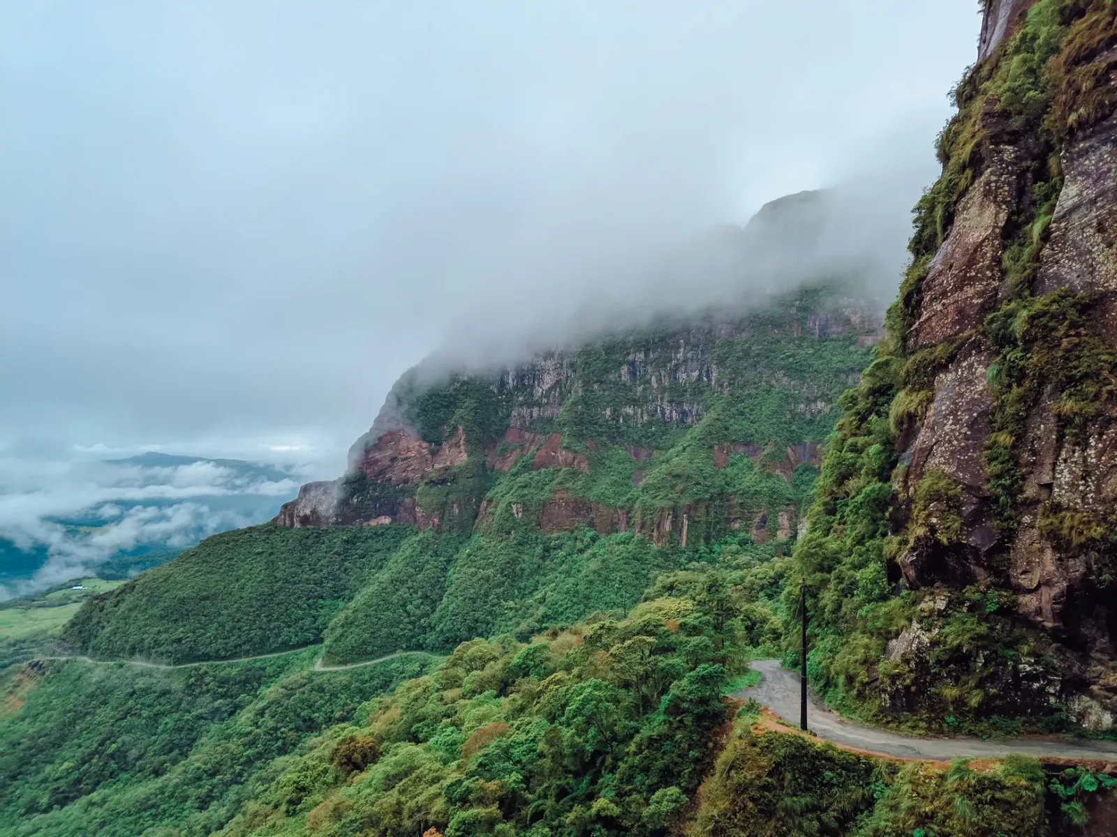 Paisaje de altura en Urubici con montañas, neblina y vegetación fría.