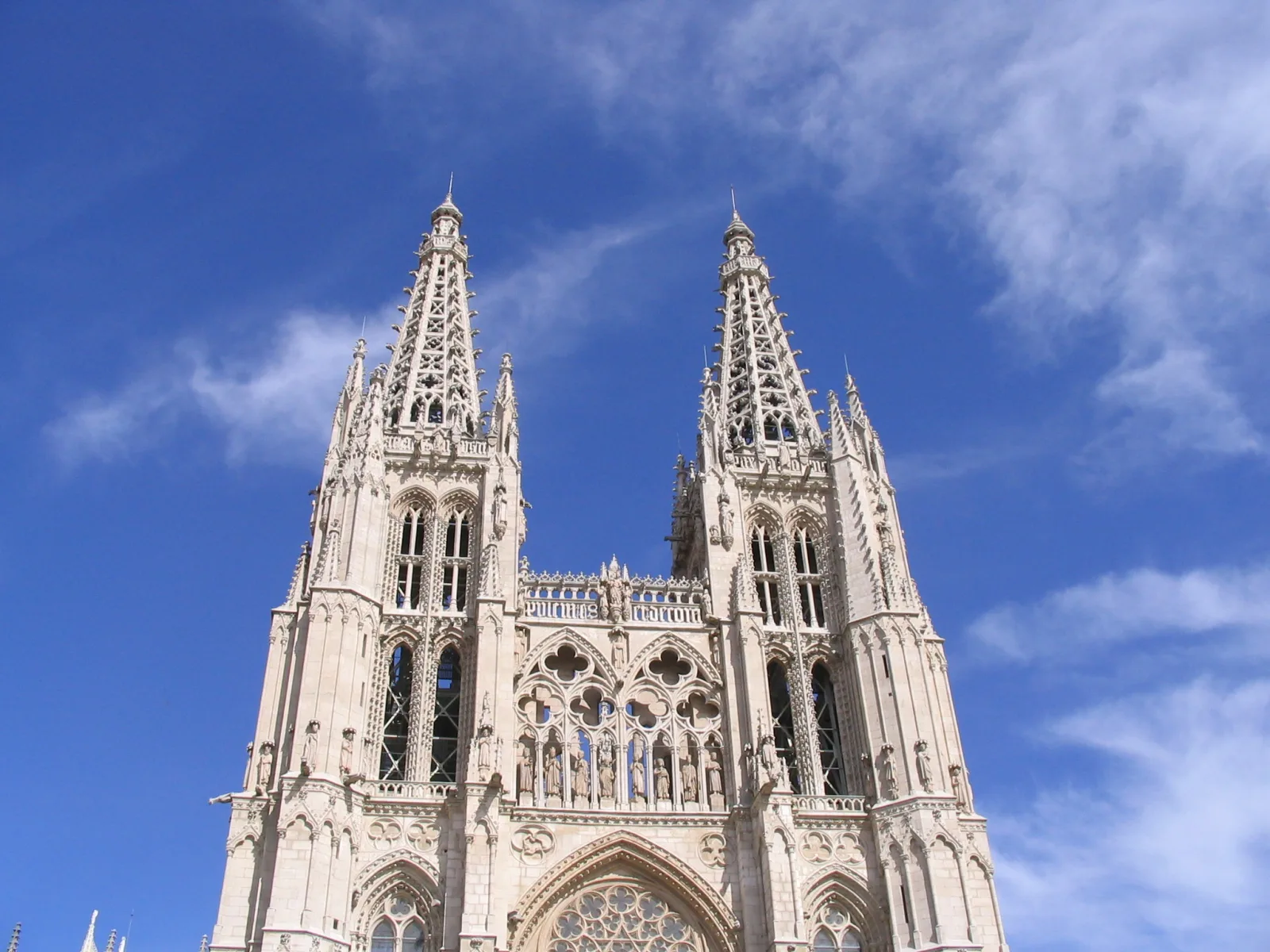 Passeio do Espolón em Burgos, com famílias caminhando ao lado do rio e das árvores.