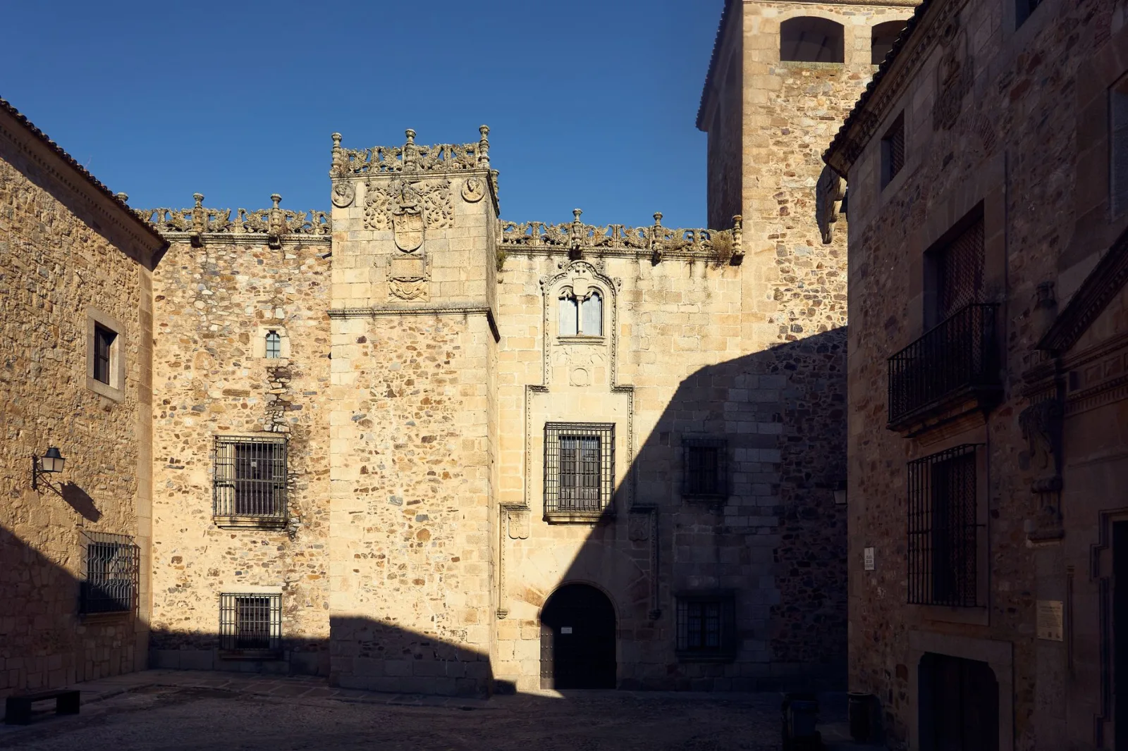 Paisagem de Cáceres com natureza e arte contemporânea ao fundo.