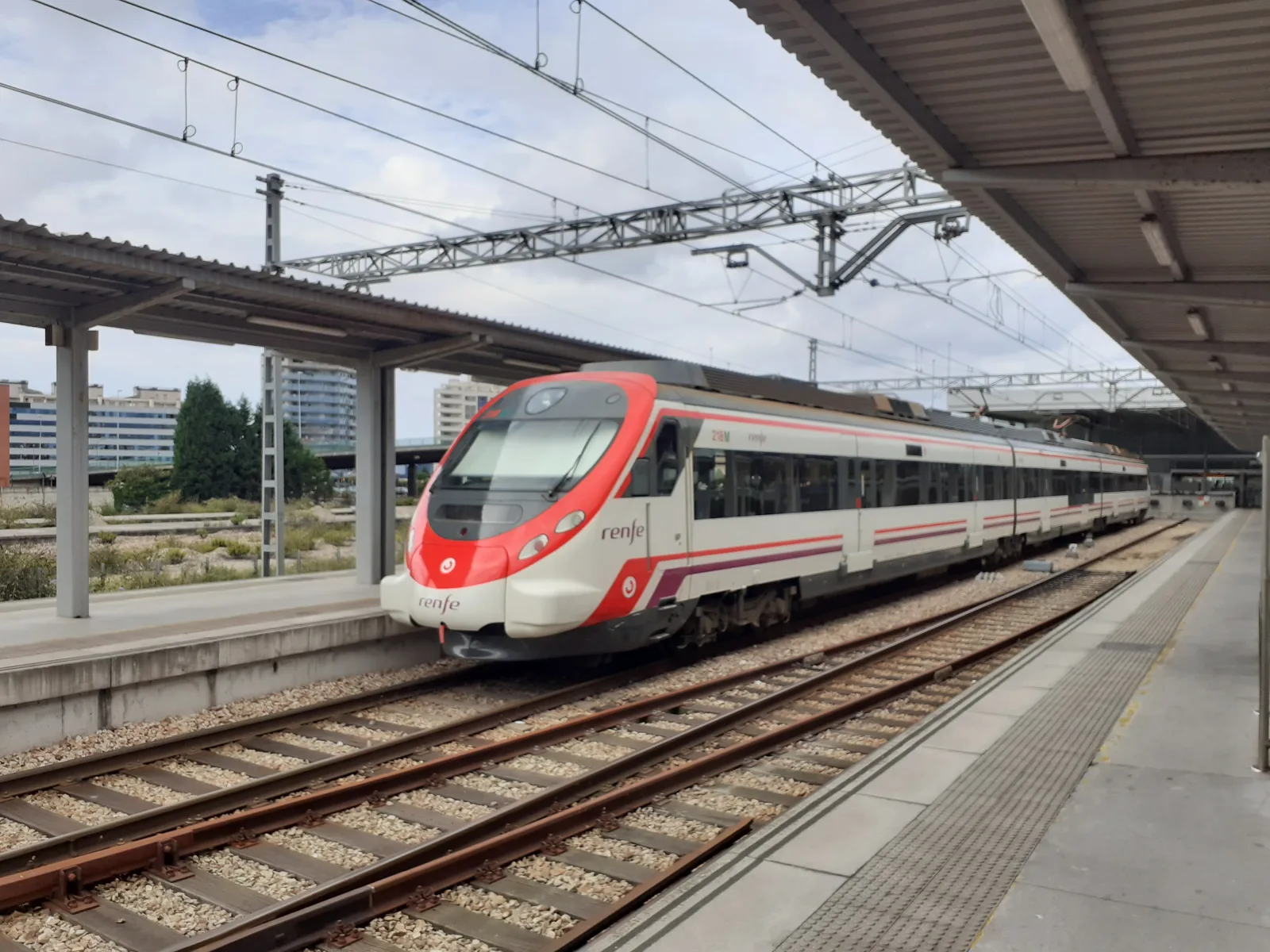 Train station in Gijón, with platform and urban structure around it.