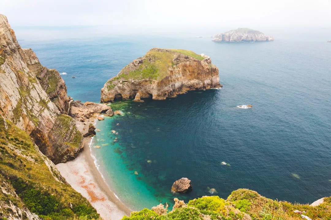 Coastal view with colorful houses and a harbor in an Asturian village.
