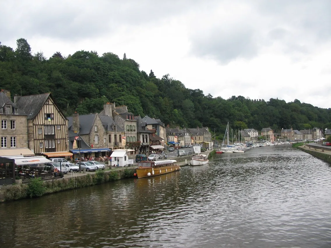 Porto de Dinan às margens do rio Rance, com barcos e encostas verdes ao redor