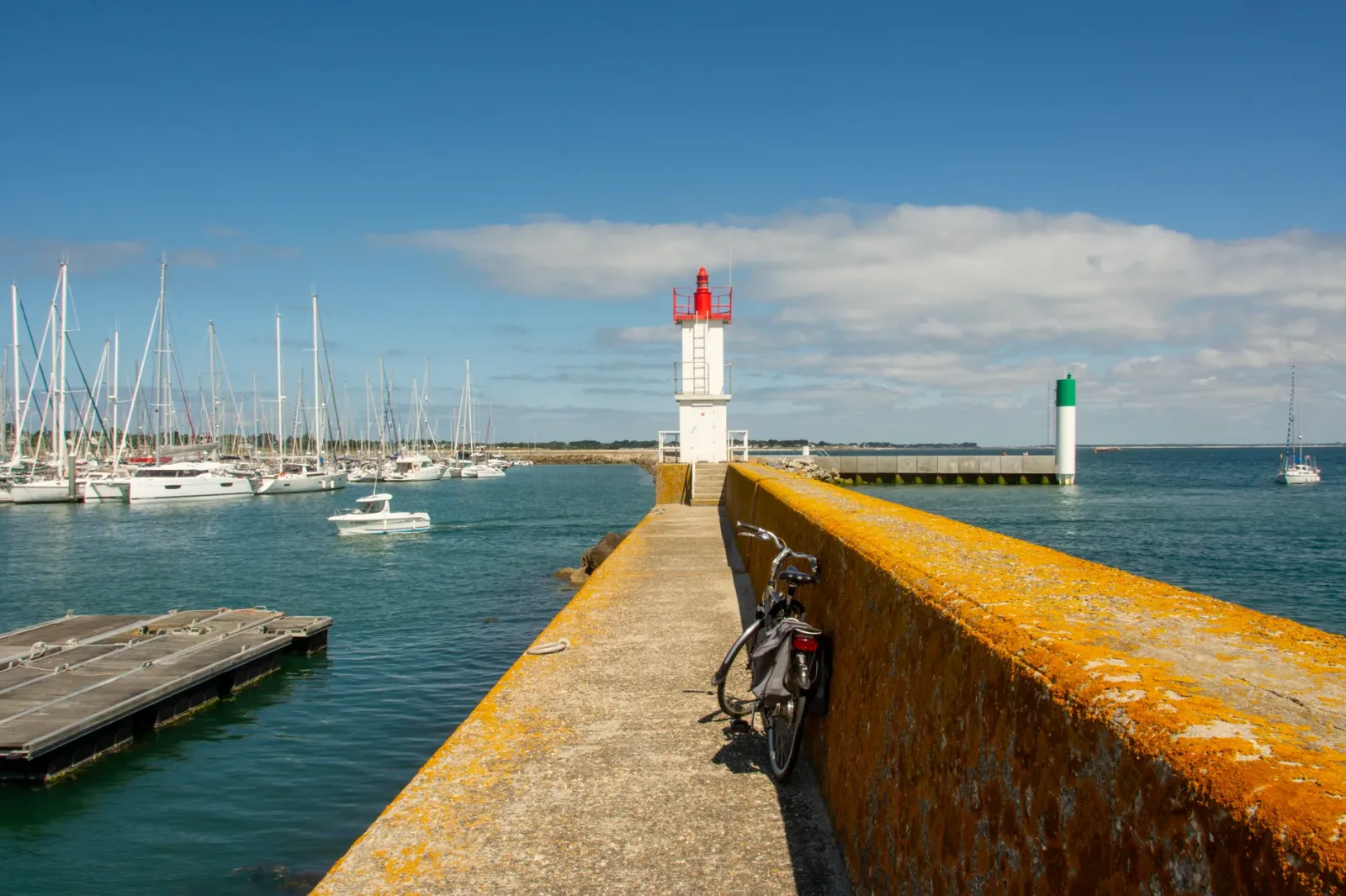 Carretera costera hacia Quiberon con un coche siguiendo rumbo al mar bajo el cielo abierto.
