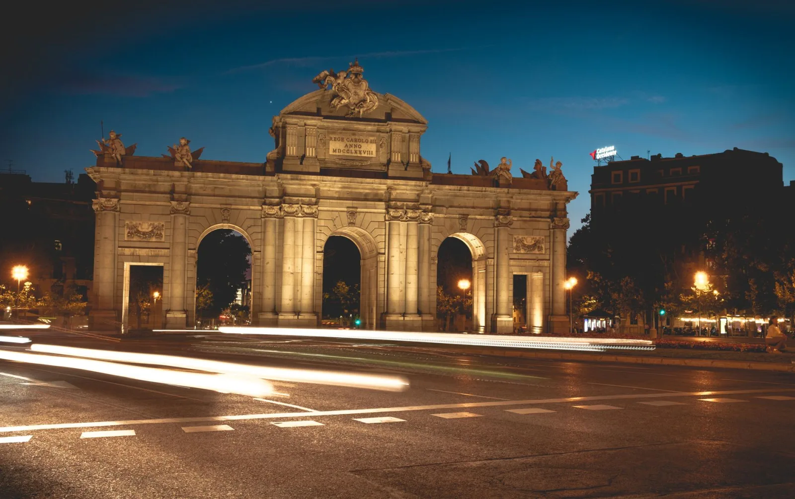 Vista de uma paisagem histórica nos arredores de Madrid, com construções e montanhas ao fundo