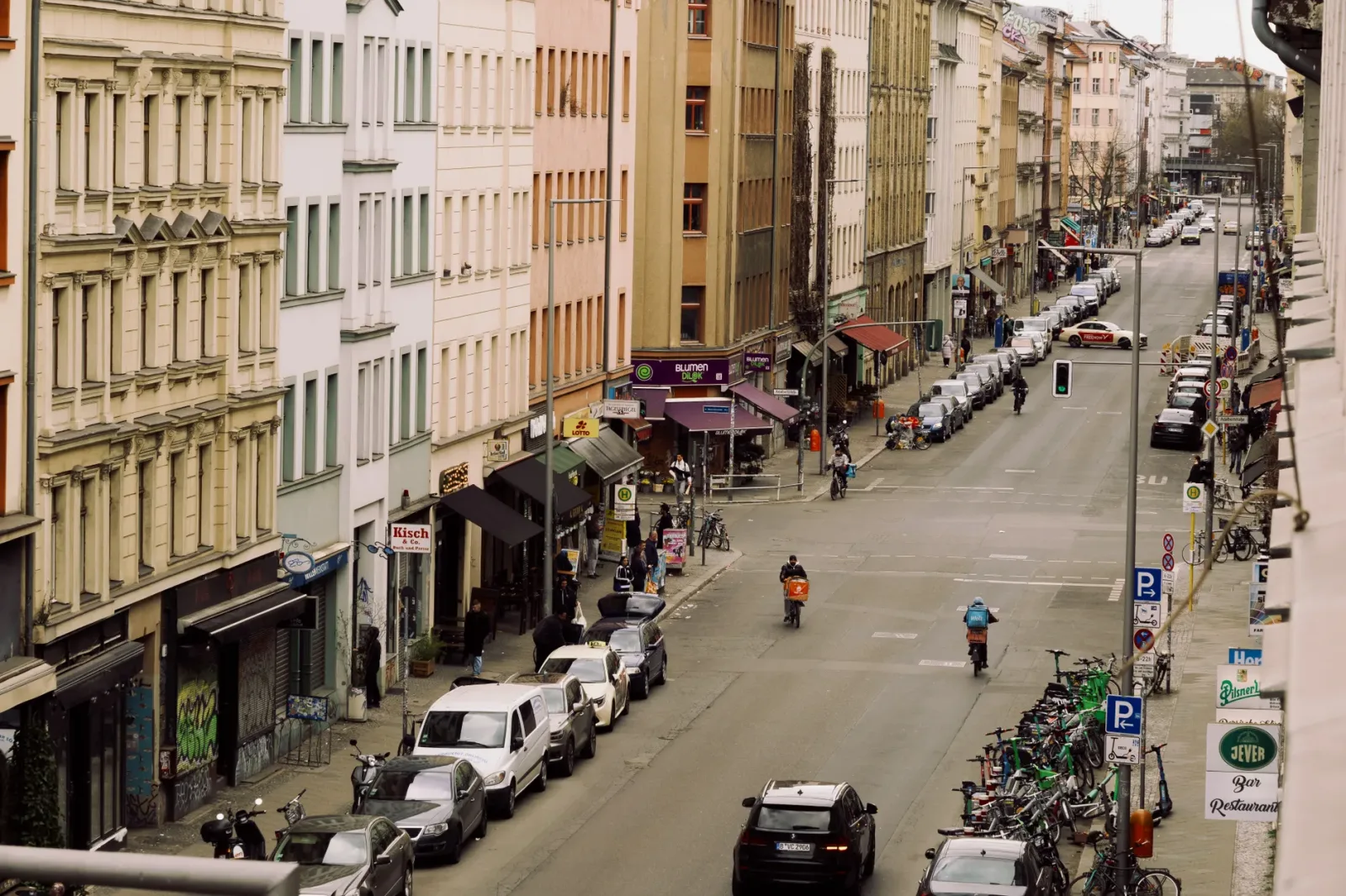 Calle de Berlín con edificios urbanos y estación cercana, ideal para alojarse con buena conexión.