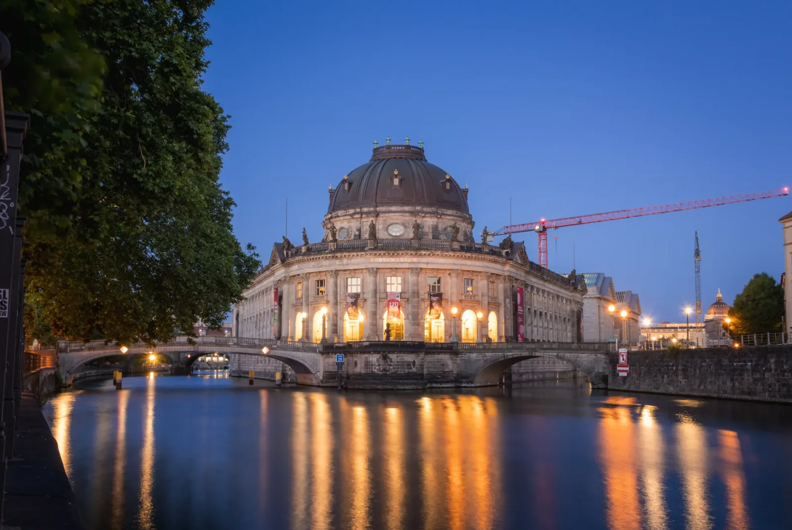 Fachada histórica de un museo en la Isla de los Museos en Berlín, con arquitectura clásica y visitantes.