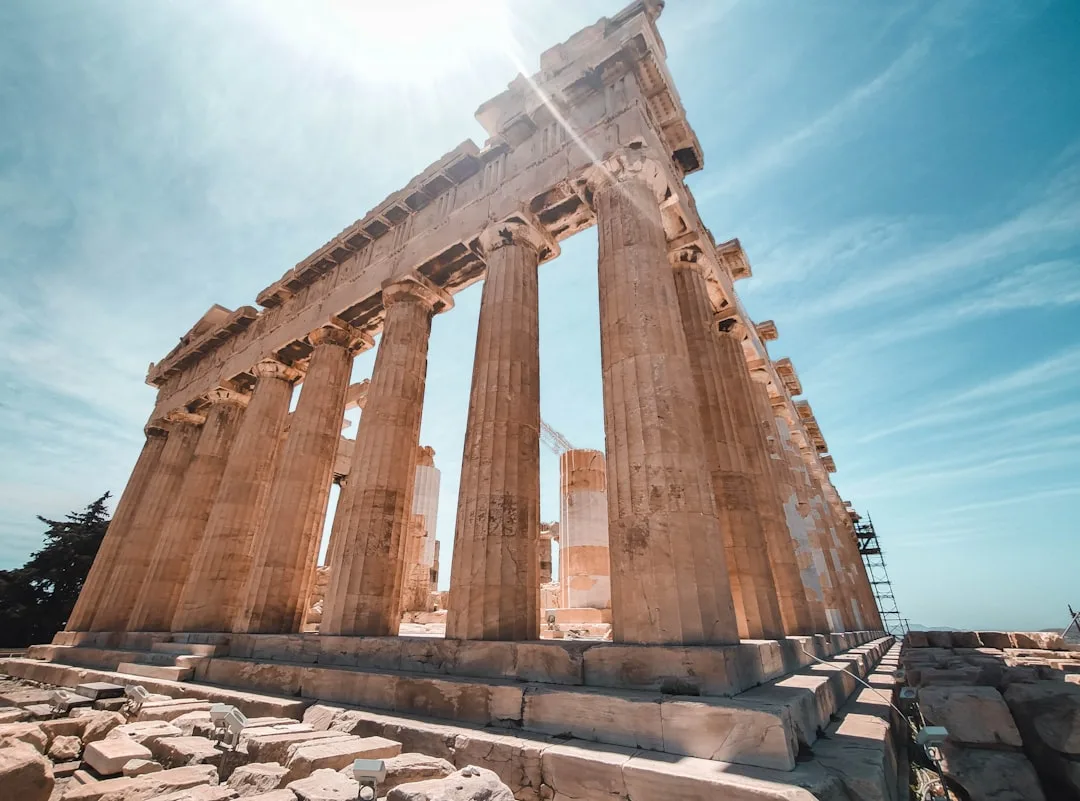 Vista panorámica de Atenas con la Acrópolis bajo un cielo despejado y luz suave.