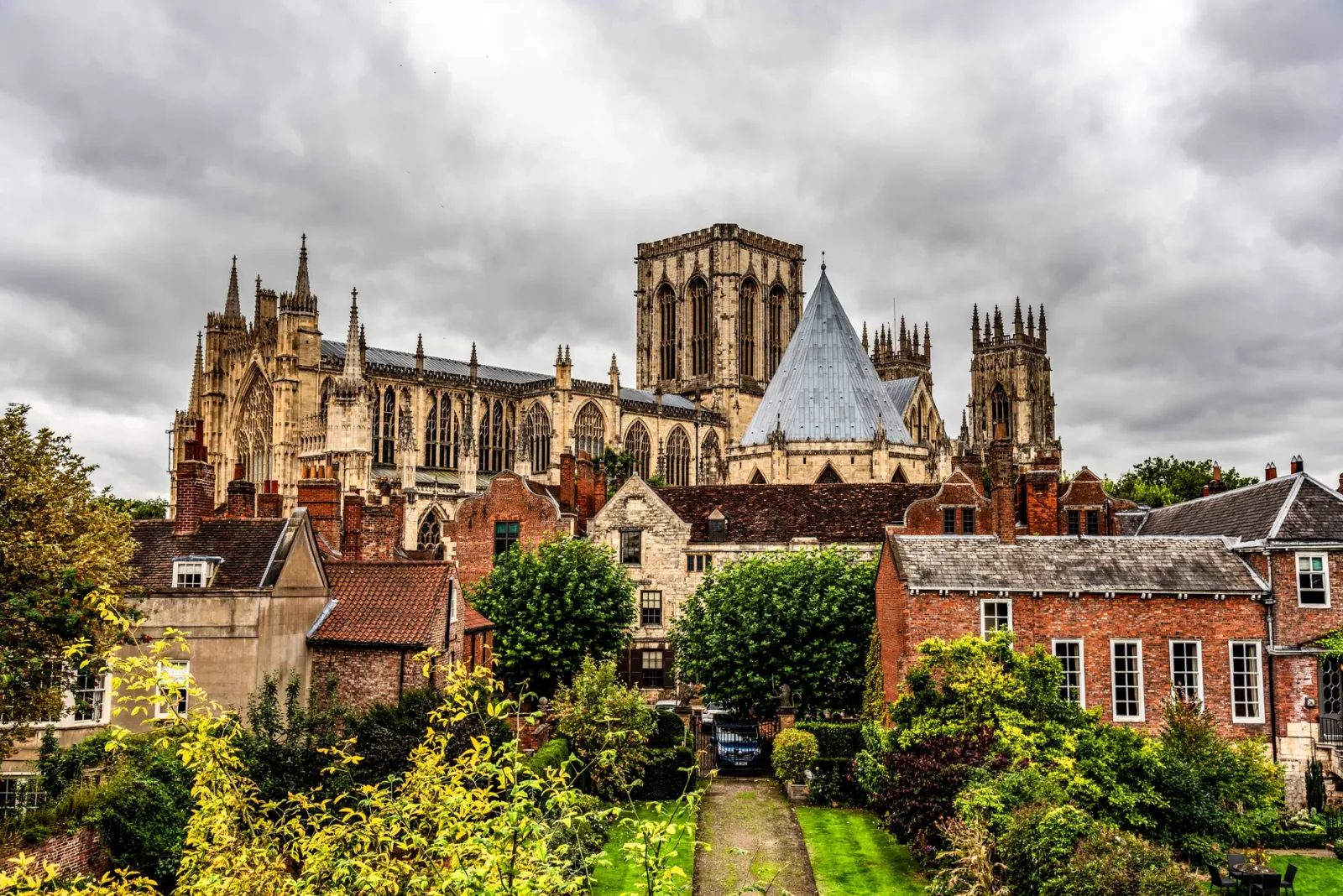 Vista da muralha histórica de York com casas antigas e céu nublado ao fundo.