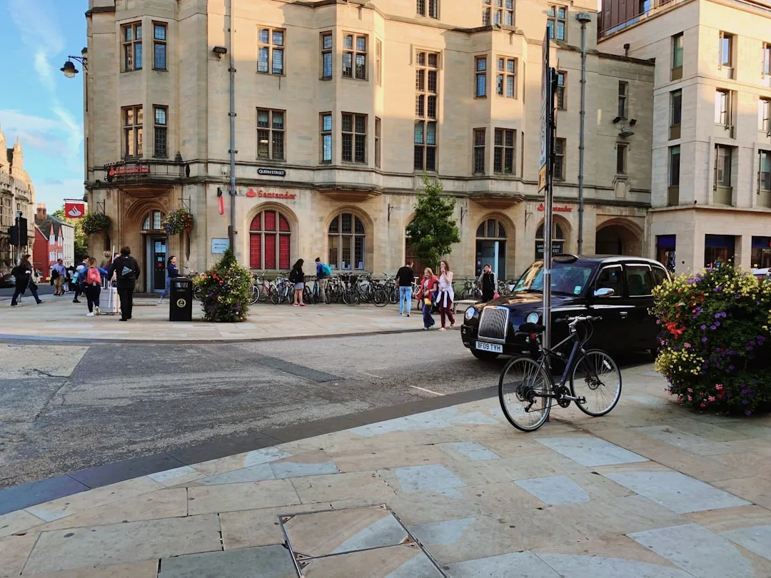 Rua de Oxford com carros e edifícios históricos ao fundo, em clima urbano tranquilo.