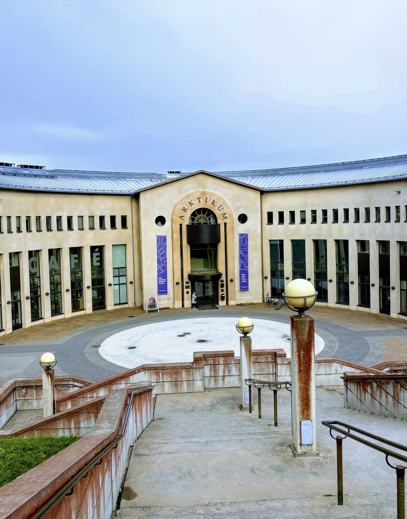 Arktikum Museum in Rovaniemi, with modern architecture by the river and Arctic landscape around