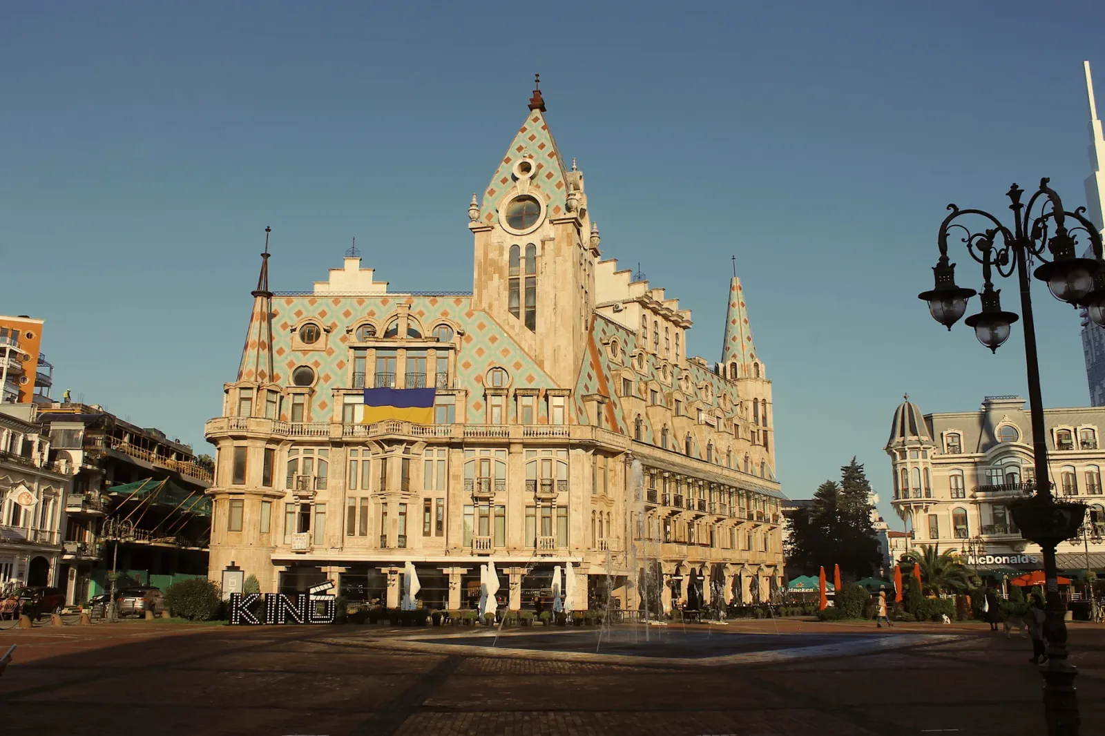 Batumi waterfront at sunset, with the city and the sea in the background.