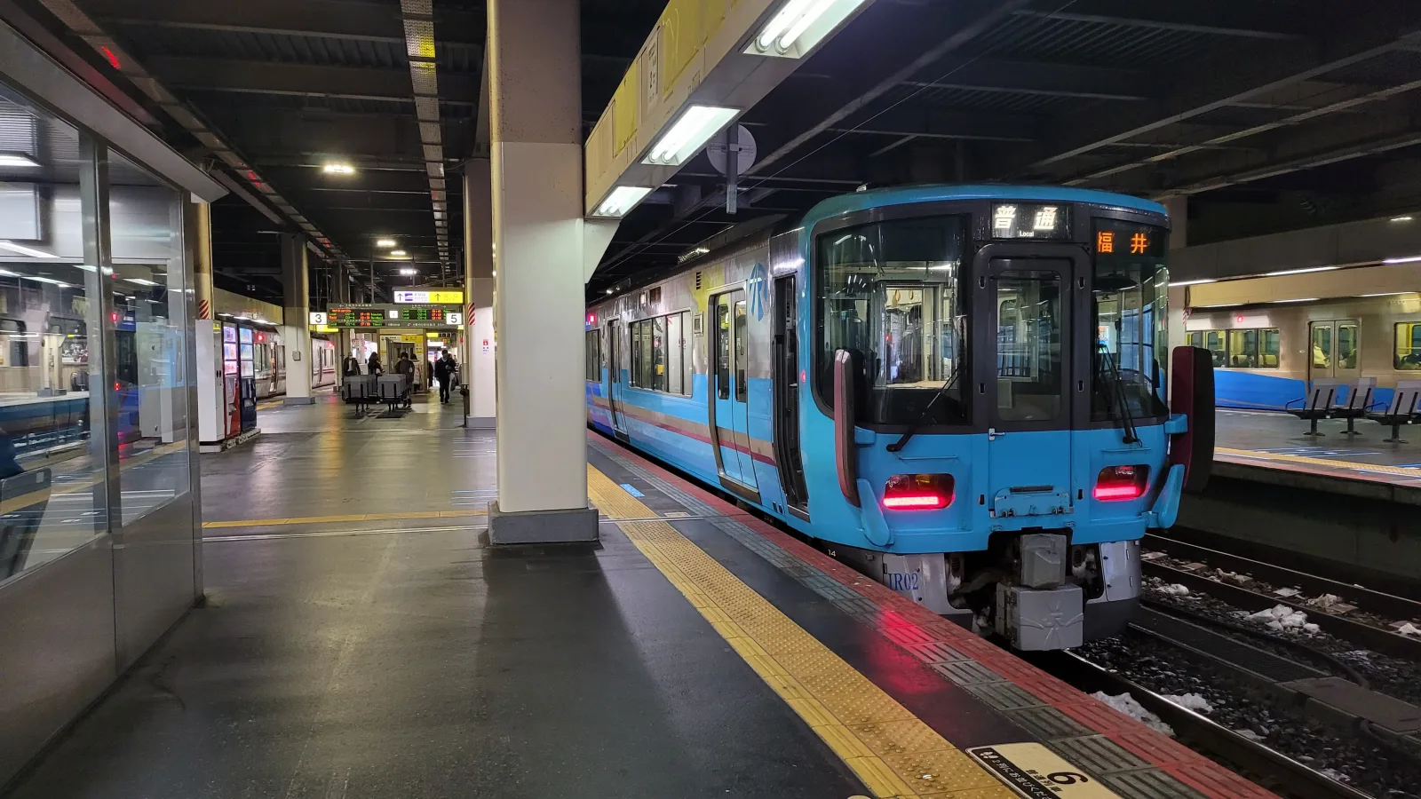Trem chegando à estação de Kanazawa, destacando o acesso ferroviário à cidade.
