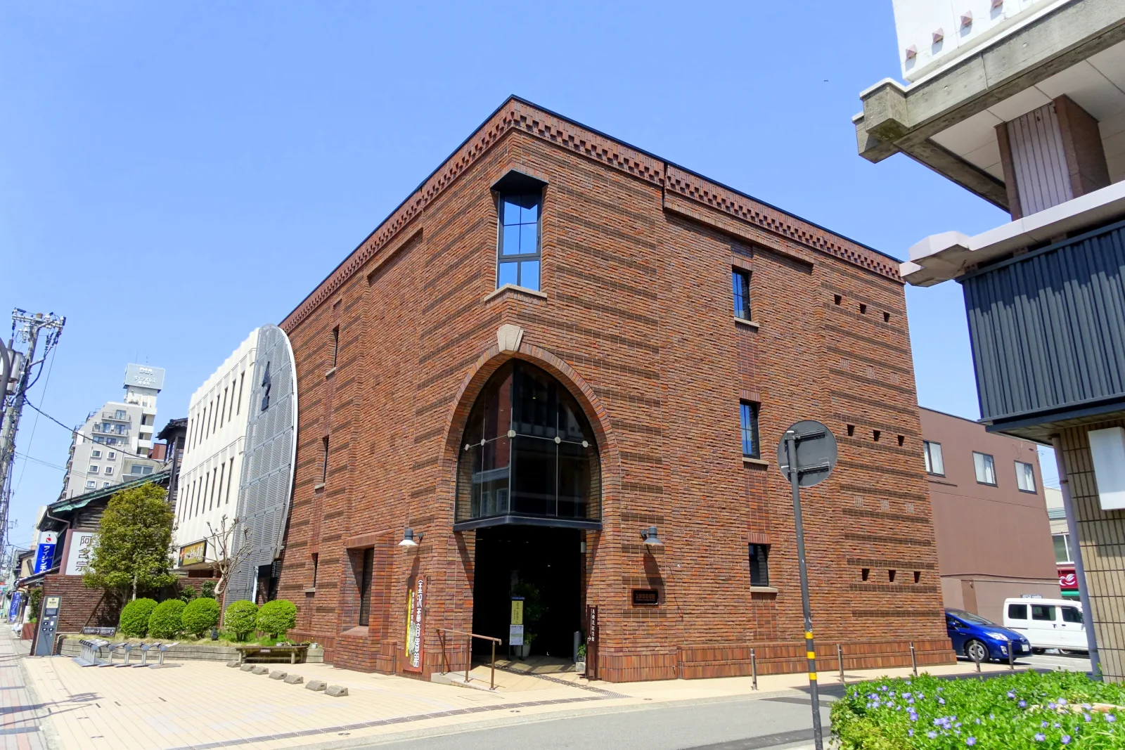 Hotéis e edifícios urbanos próximos à Kanazawa Station em uma rua movimentada.