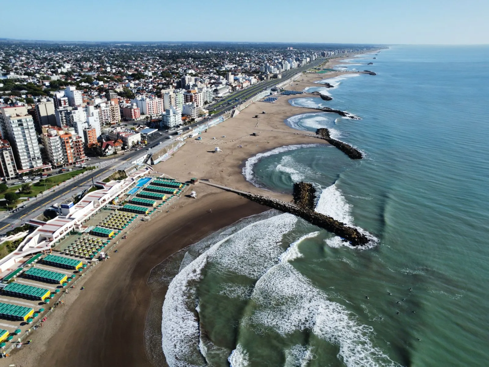 Mar del Plata beach with rough sea and summer activity under an open sky