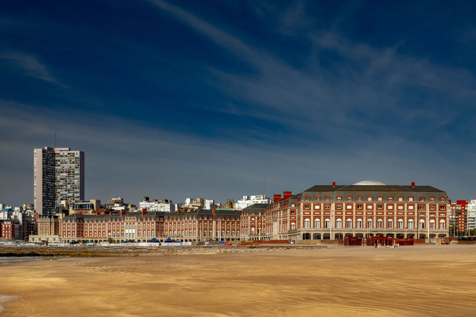View of the Mar del Plata waterfront with buildings and beach in the background, suggesting accommodation near the sea