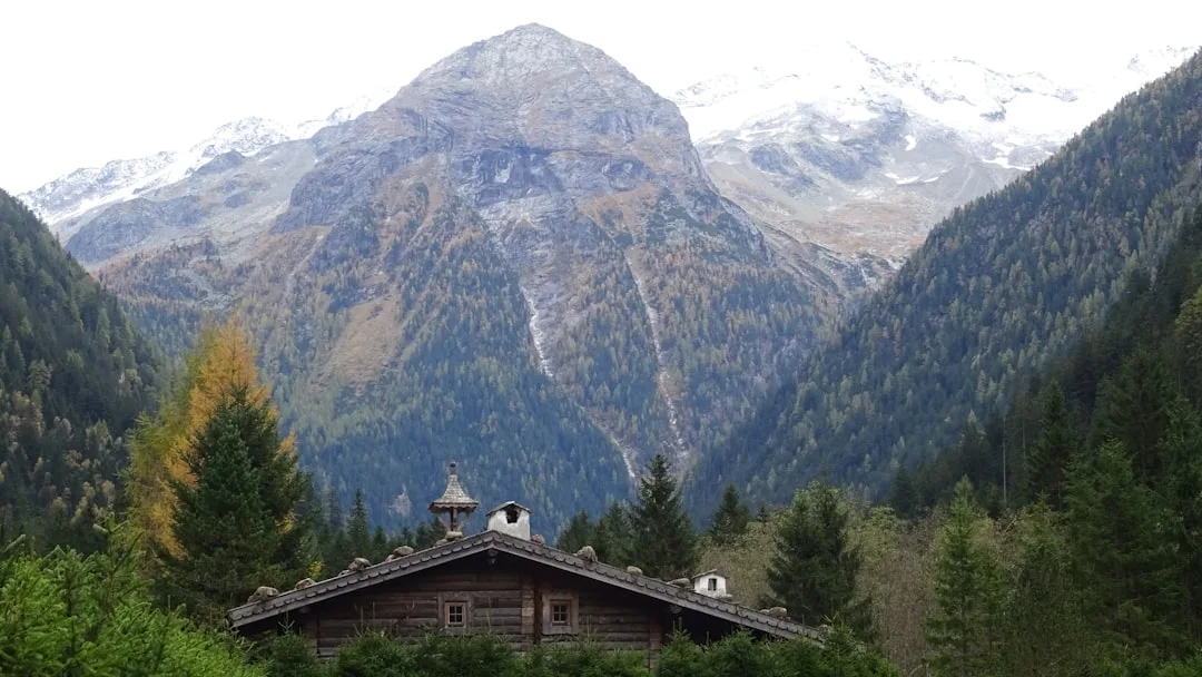 View of Bad Gastein with mountains, a central waterfall, and Alpine buildings around it.