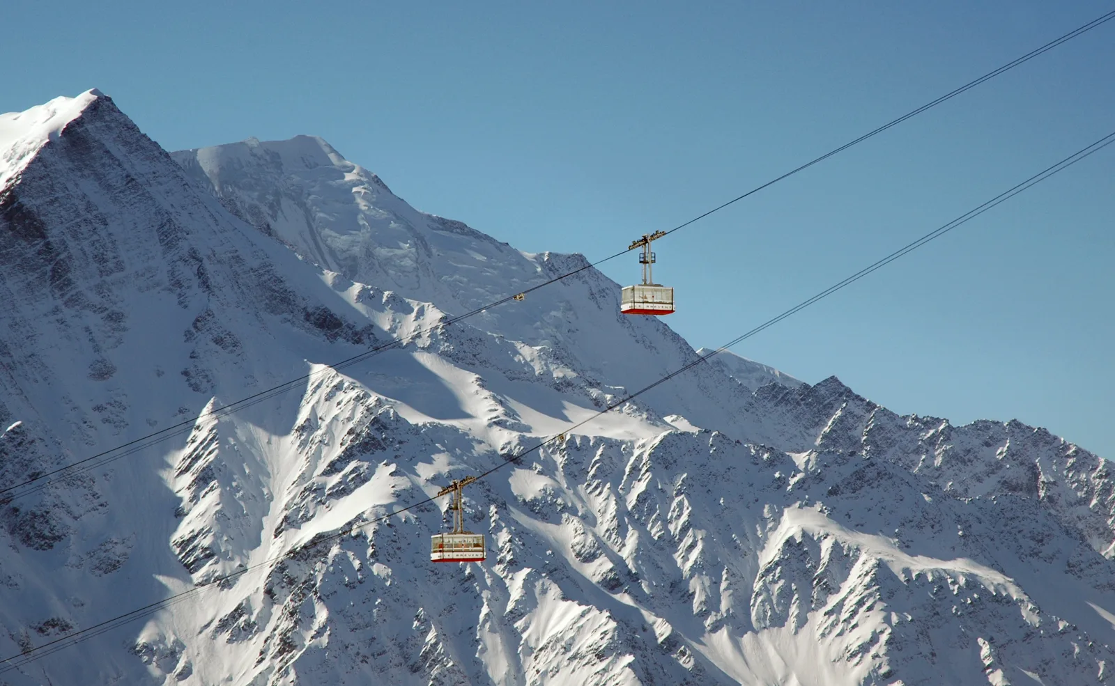 Ônibus Le Mulet circulando pelas ruas de Chamonix, com montanhas ao fundo