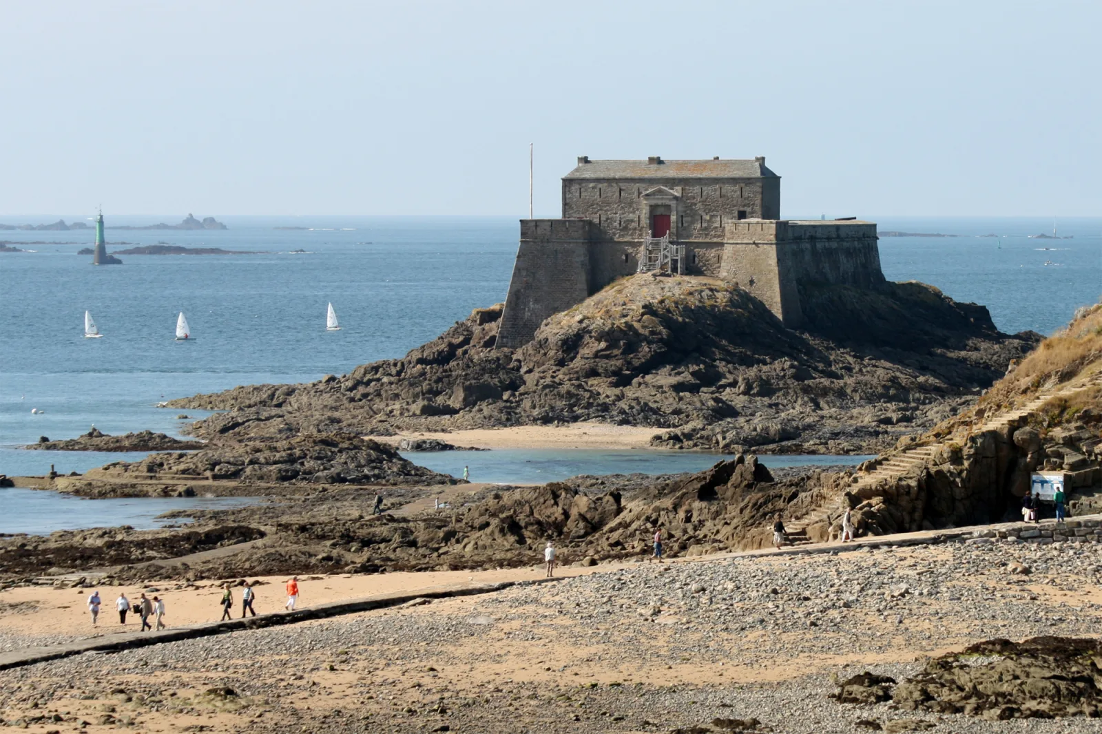 Beach and ramparts of Saint-Malo at low tide, revealing a strip of sand and coastal access