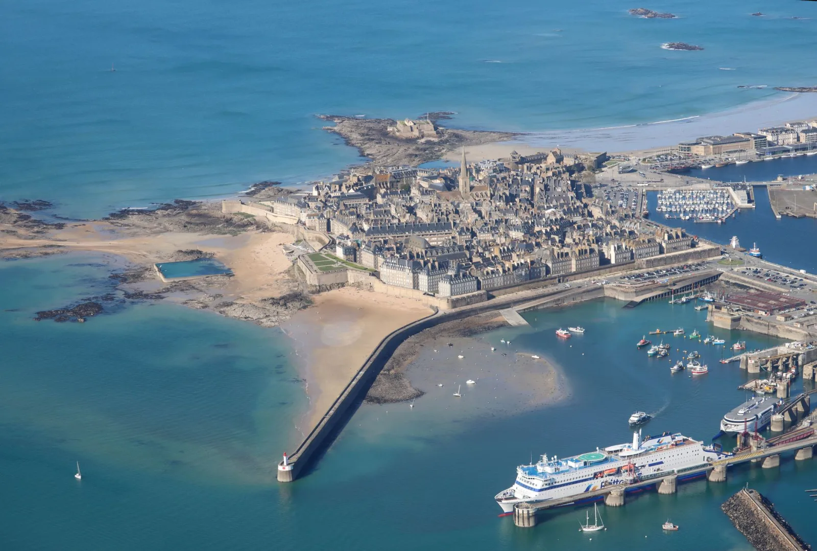 Saint-Malo walls and harbor by the sea, with boats and low tide on the coast of Brittany