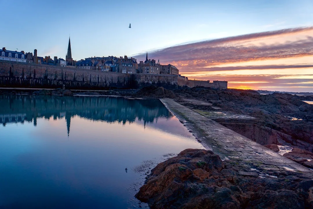 Saint-Malo seaside ramparts, with historic houses and a view of the bay at low tide