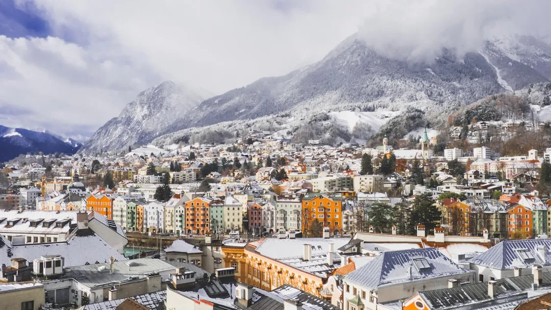 Vista panorámica de Innsbruck rodeada por montañas nevadas y edificios coloridos