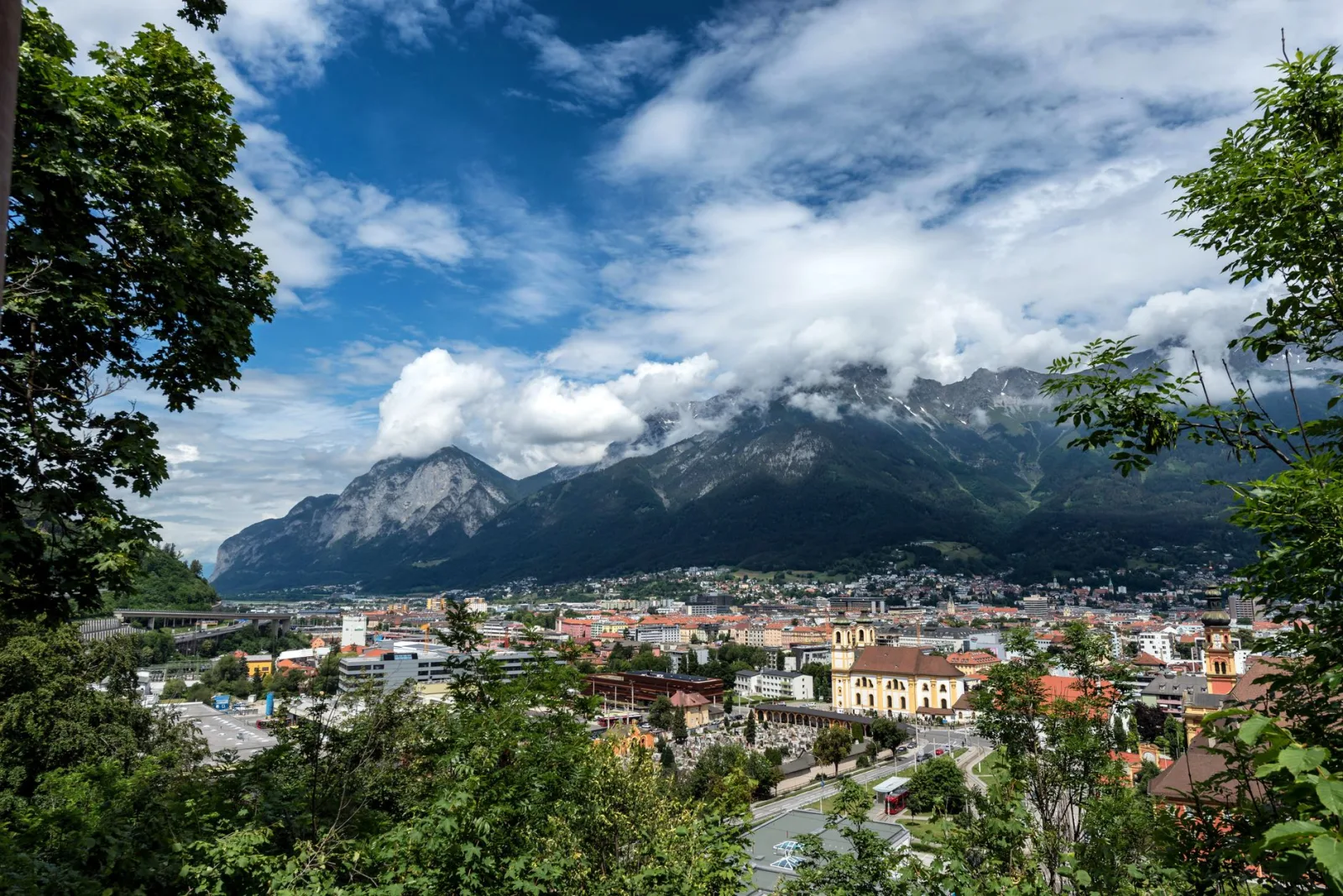 Centro de Innsbruck con los Alpes al fondo y teleférico, escena que sugiere la Innsbruck Card.