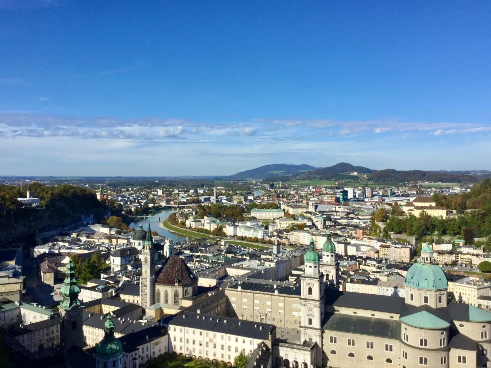 Vista panorámica de Salzburgo con edificios históricos y montañas al fondo