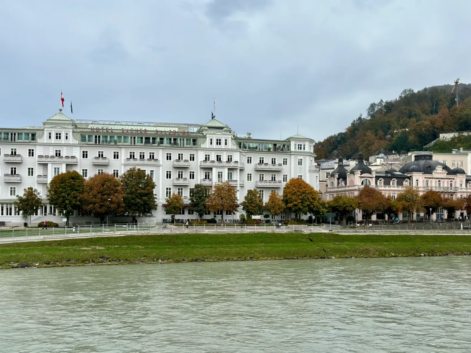 Casas históricas y río en Salzburgo, con una vista encantadora del centro antiguo andino al fondo
