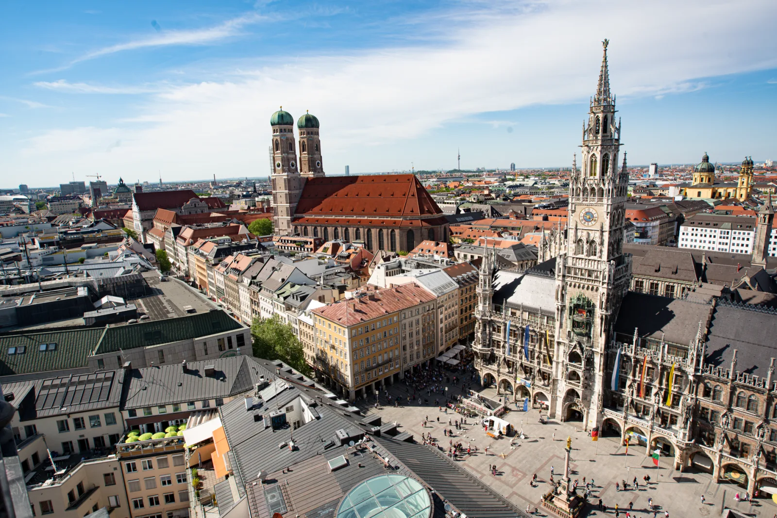 Urban view of Munich with historic buildings and a bustling square at dusk