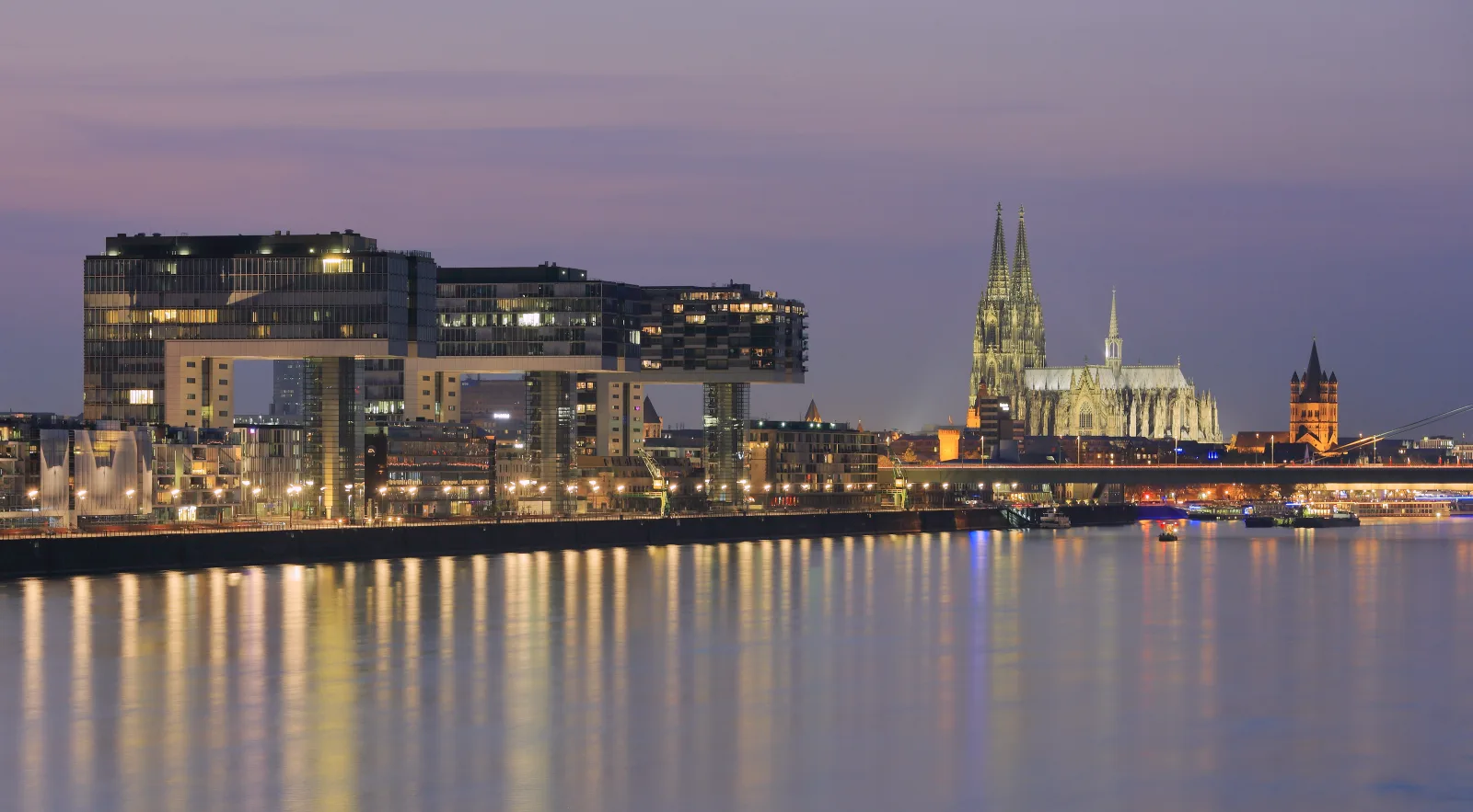 Cologne Cathedral on the banks of the Rhine River, with the city in the background.