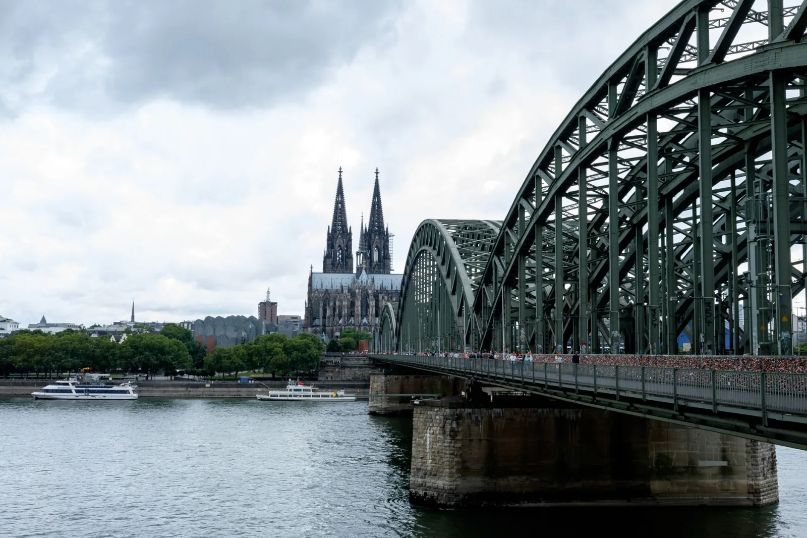 Historic squares of Cologne with old buildings, a statue, and bars in a vibrant urban setting.