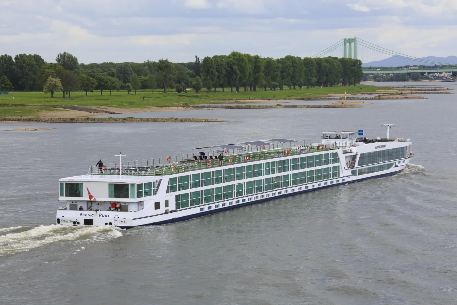 Rhine embankment in Cologne with Fischmarkt, historic houses, and the Hohenzollern Bridge in the background