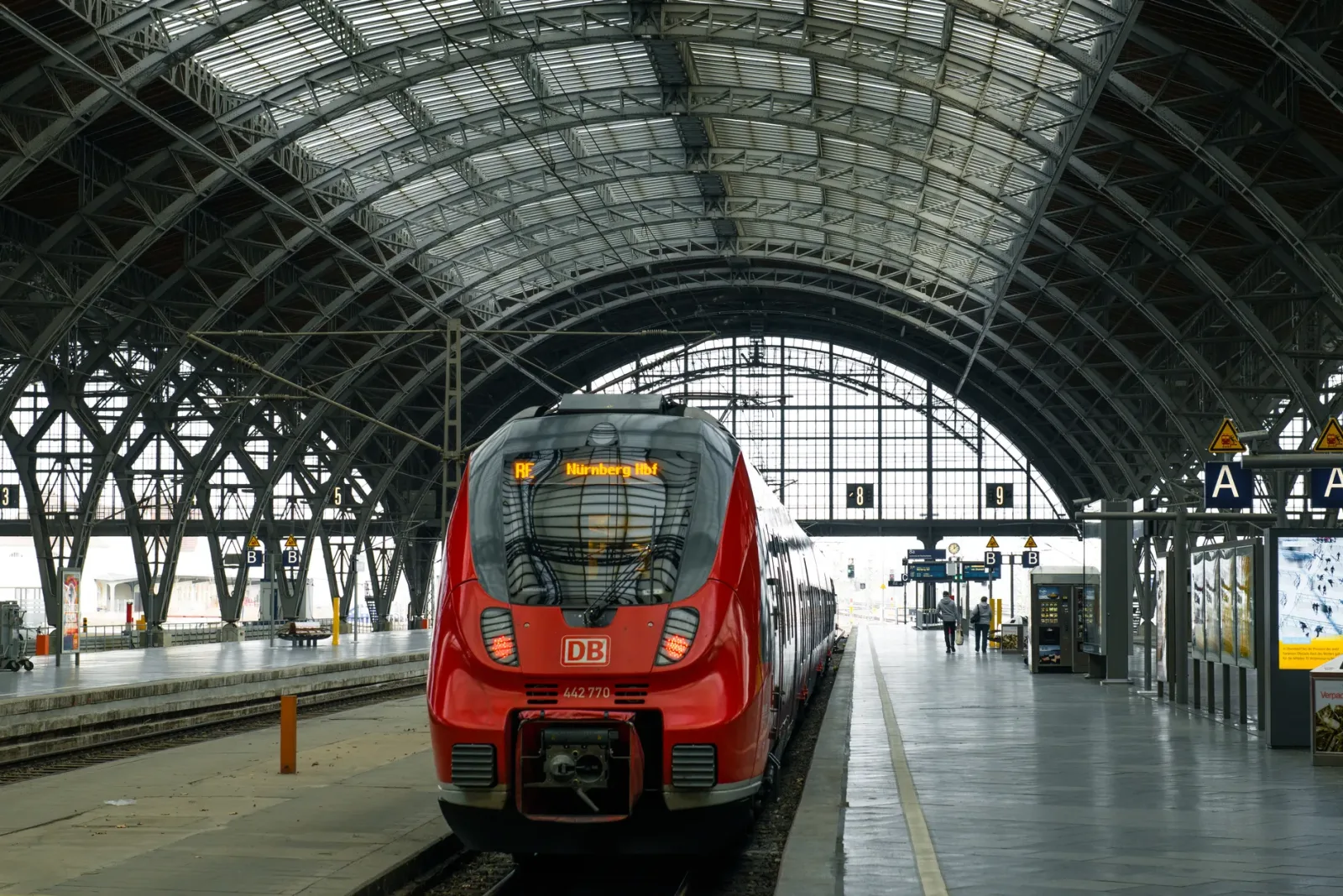 Estación central de Leipzig con tranvías y peatones en el camino hacia el centro histórico.