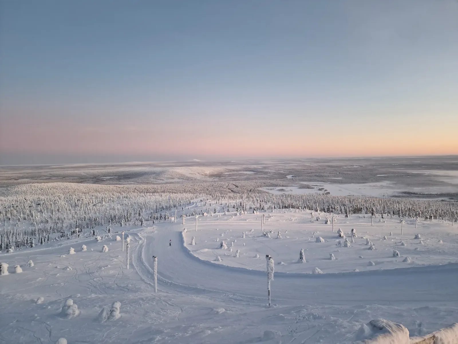Paseo en moto de nieve por el bosque nevado de Ivalo bajo el cielo invernal.