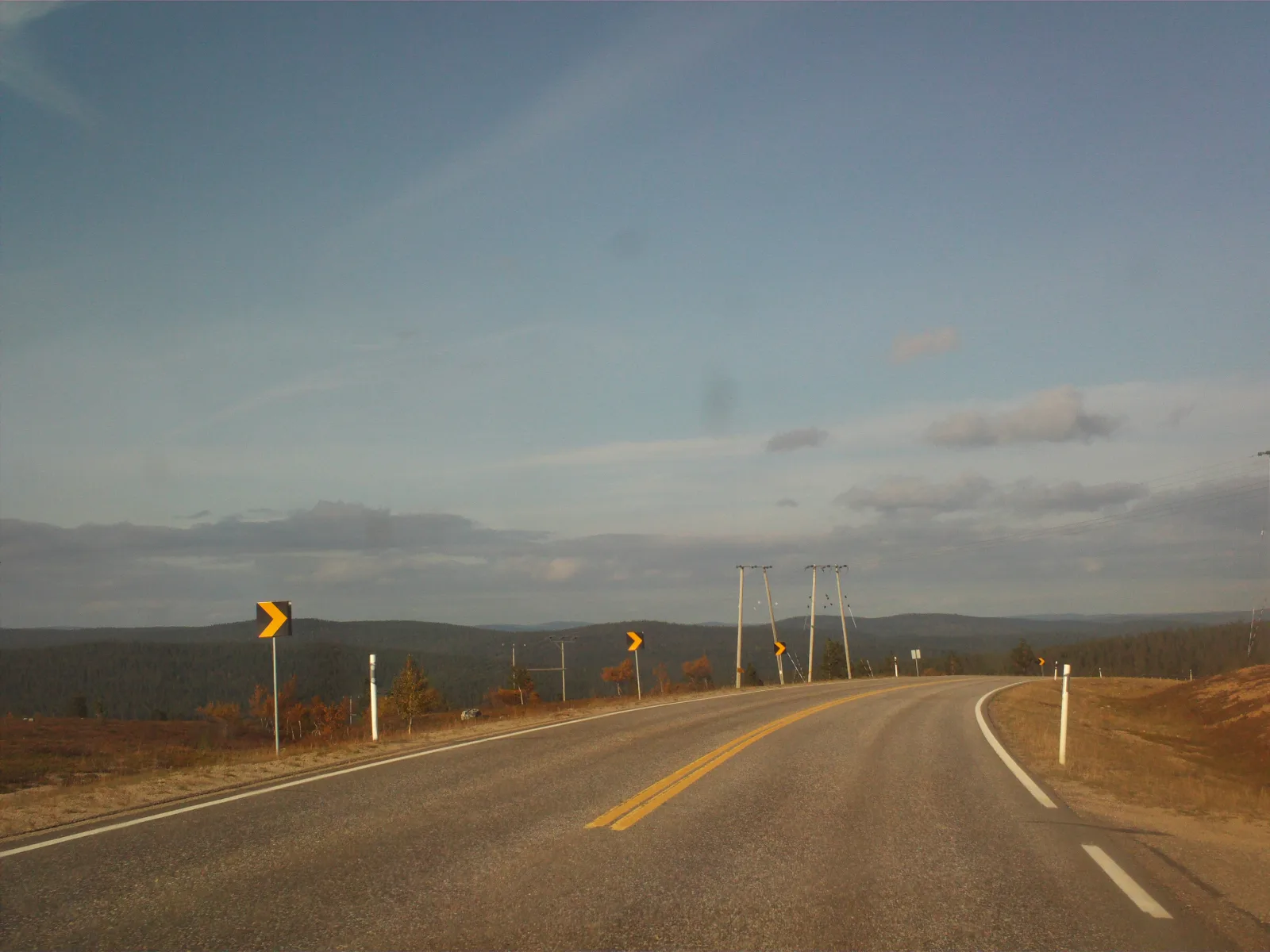 Carretera nevada en Laponia, con autobús y paisaje ártico rumbo a Saariselkä