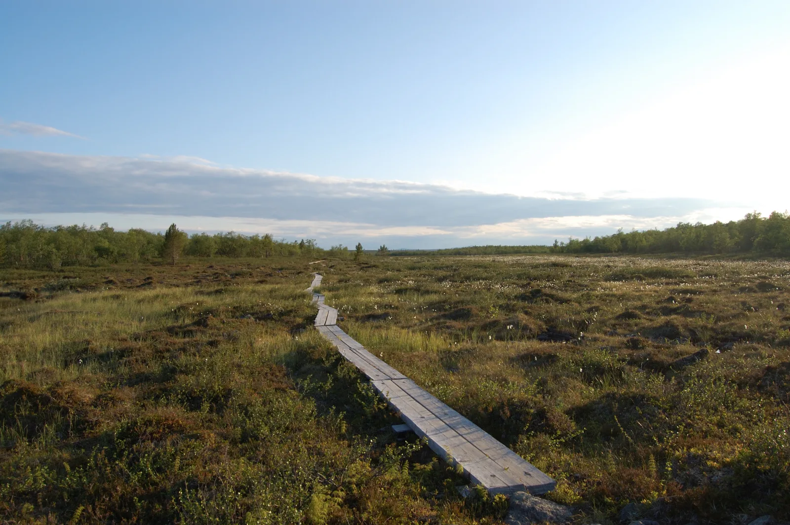 Calle nevada de Saariselkä con autobús local y peatones en el pueblo
