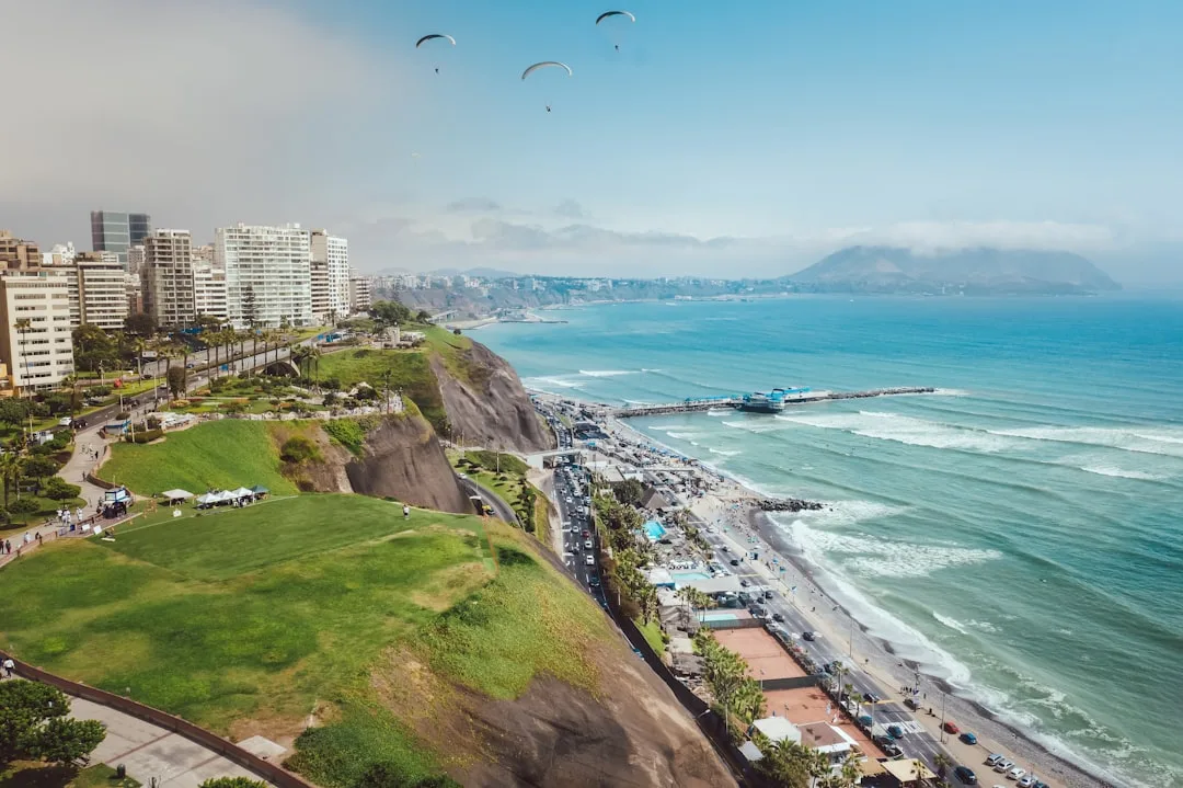Ciclistas en el Malecón de Barranco, con arte callejero y vista costera en Lima.