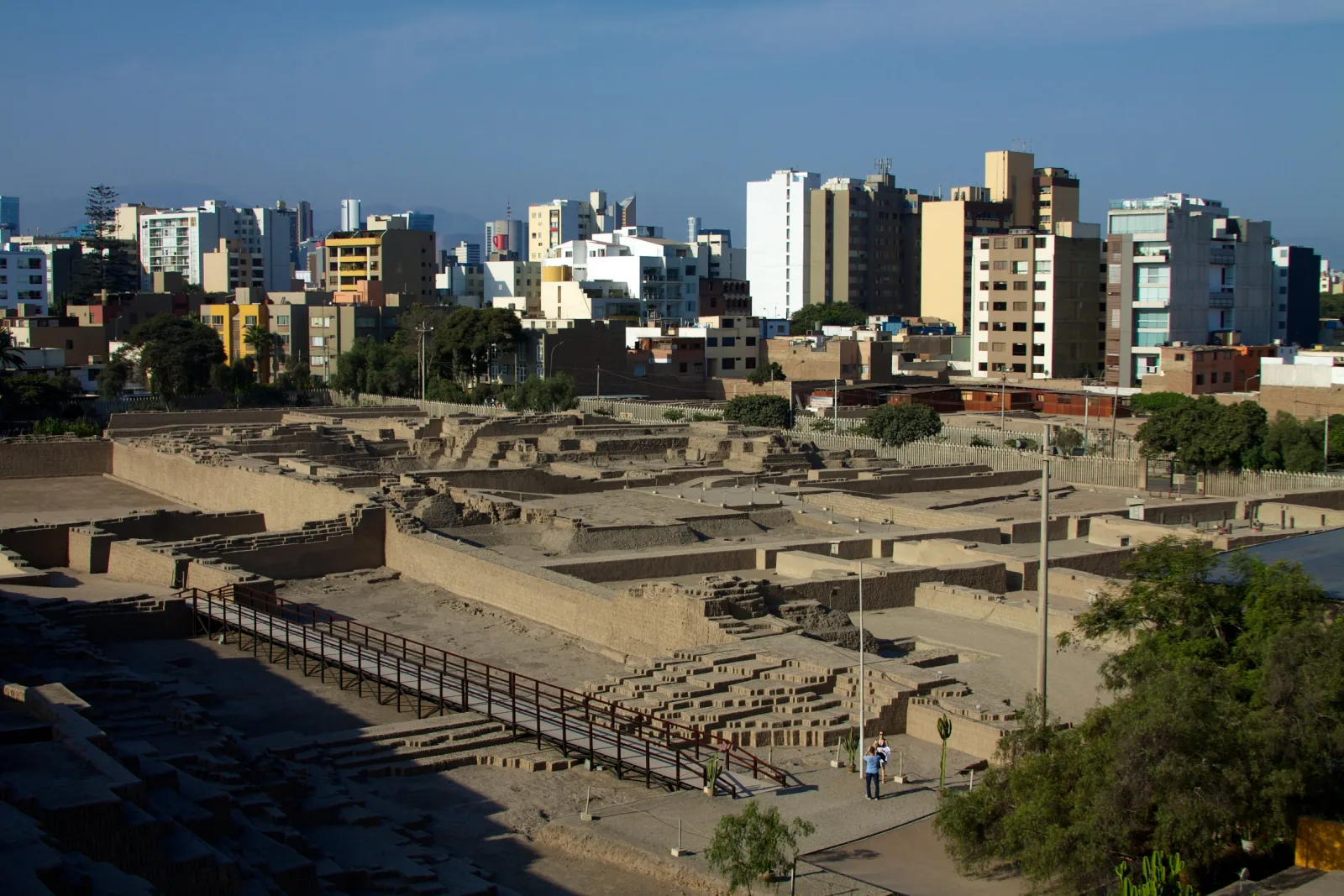 Ruinas de adobe de la Huaca Pucllana, con paredes geométricas bajo el cielo de Lima.
