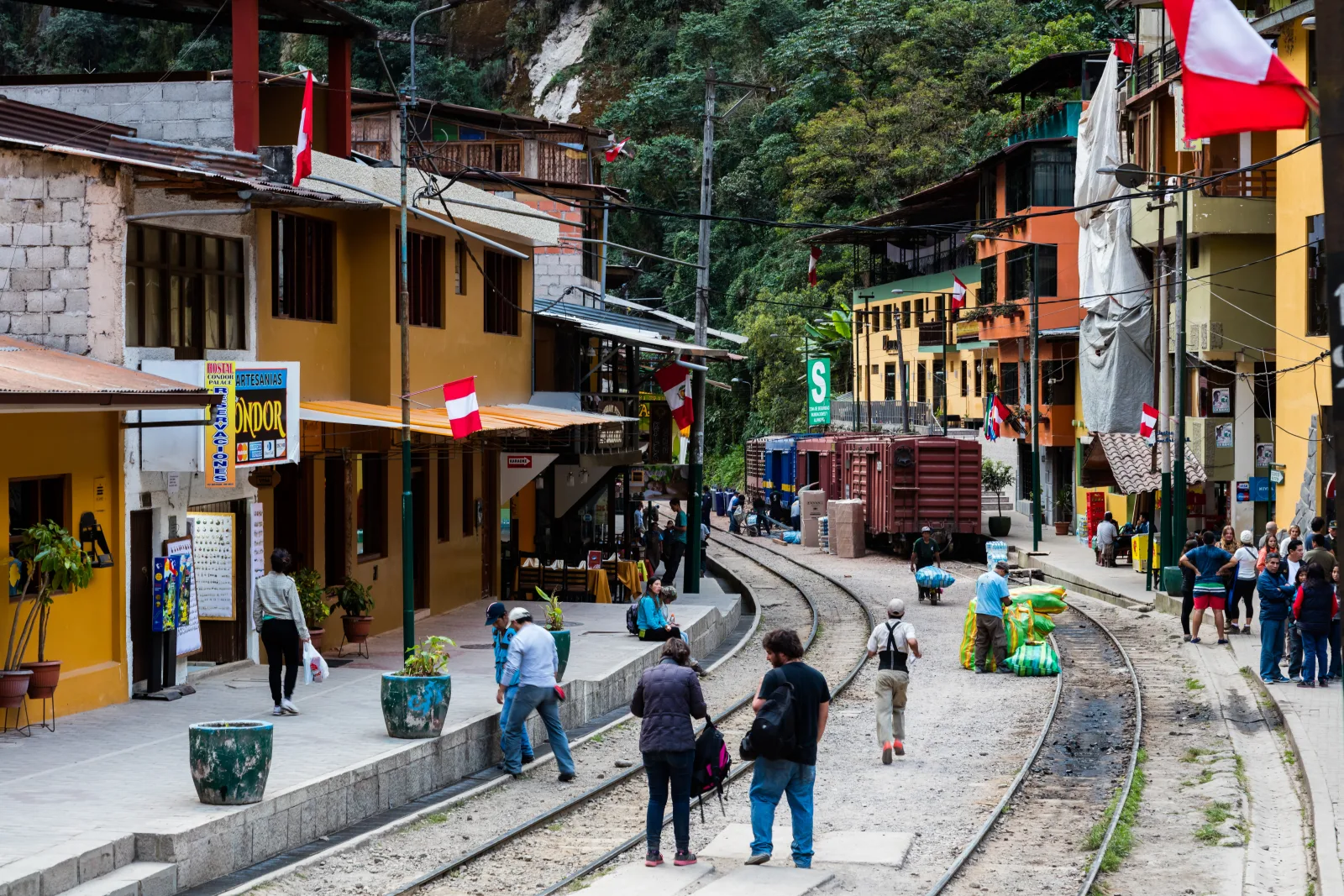 View of Aguas Calientes surrounded by green mountains and a river in the background