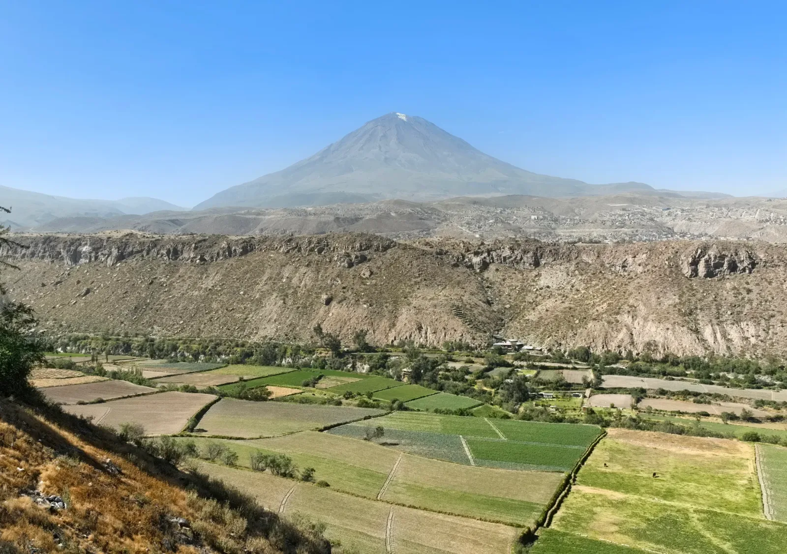 Vista panorámica de Arequipa con casas blancas y volcanes al fondo